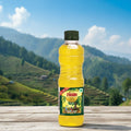 Bottle of Figaro 100 ml olive oil on a wooden surface with a mountainous landscape in the background