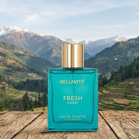 Bellavita Fresh Unisex perfume bottle on a wooden surface with a mountainous landscape in the background