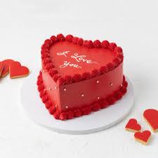 Heart-shaped red cake with 'I love you' text on a white background