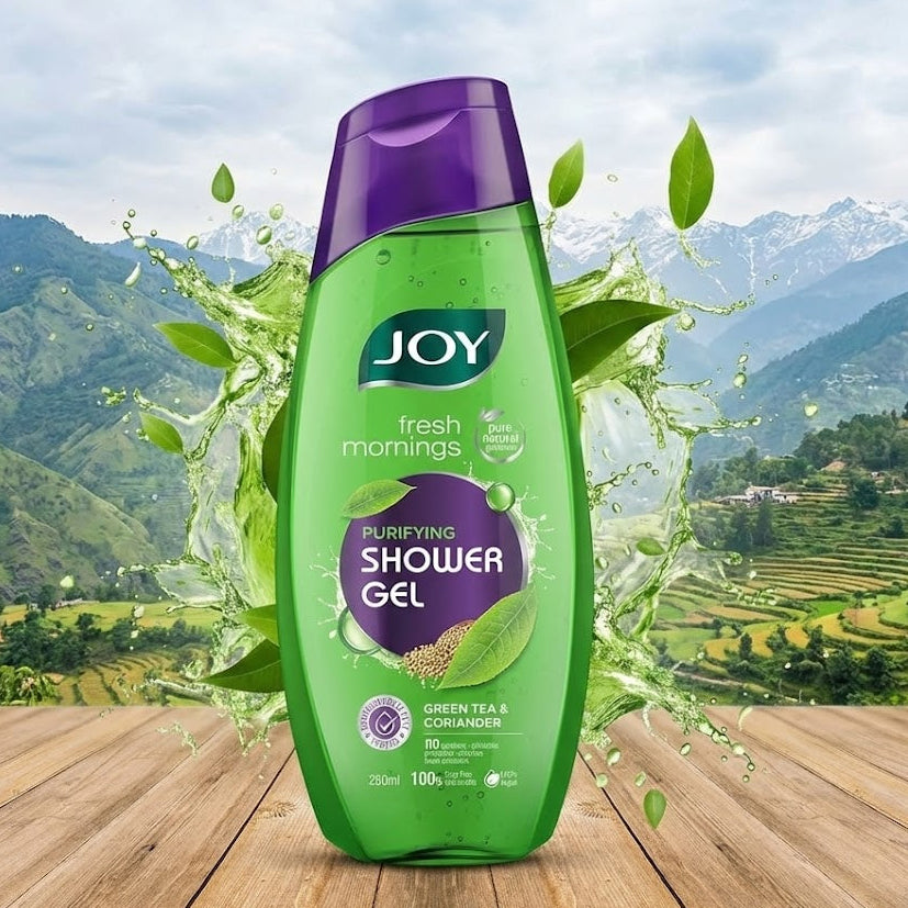 Green bottle of JOY shower gel with a mountainous landscape in the background