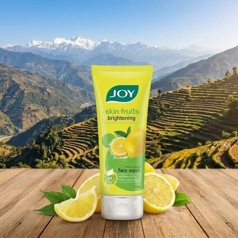 JOY skin fruits brightening face wash with lemons on a wooden surface with a mountainous background