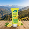 JOY skin fruits brightening face wash with lemons on a wooden surface with a mountainous background
