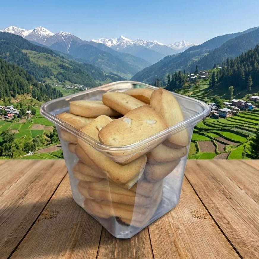 Clear container of cookies on a wooden surface with a mountainous landscape in the background