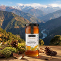 Jar of Kapiva Organic Honey with a mountainous landscape in the background