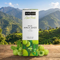 Kapiva Amla Juice packaging with green amla fruits on a wooden surface with a mountainous background
