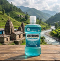 Bottle of Listerine Cool Mint mouthwash on a wooden surface with a scenic background of mountains and a river.