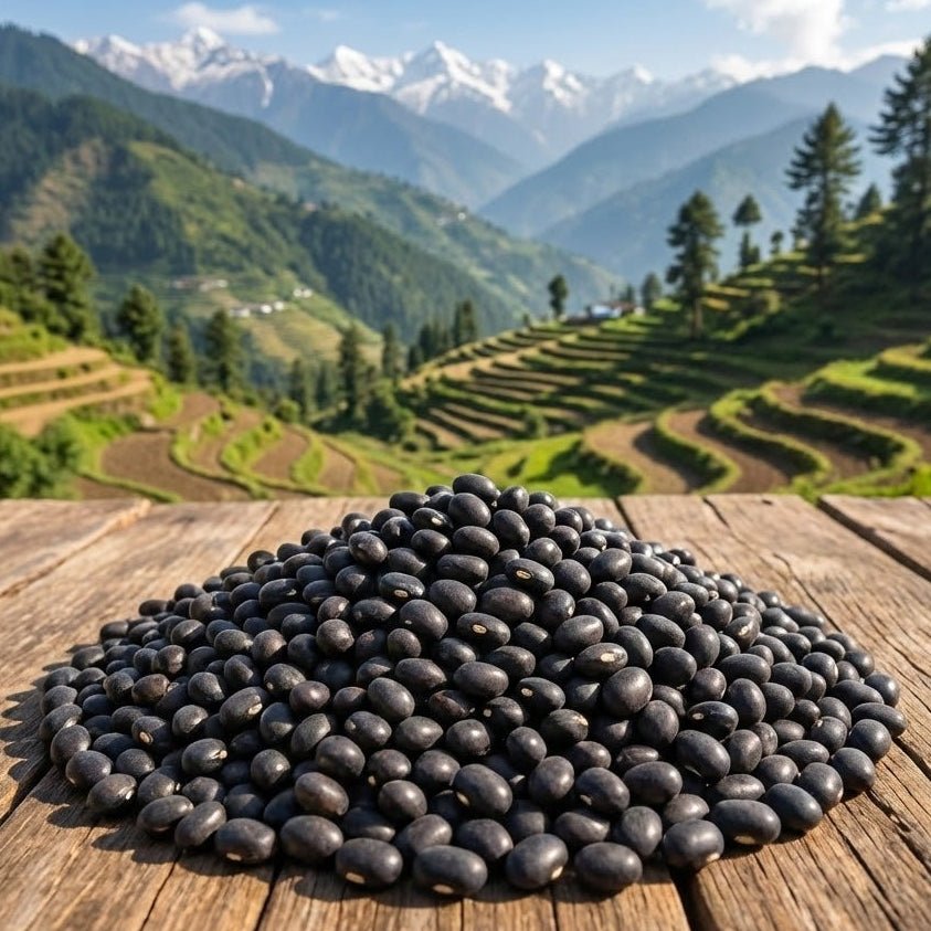 Pile of black beans on a wooden surface with a scenic mountain landscape in the background