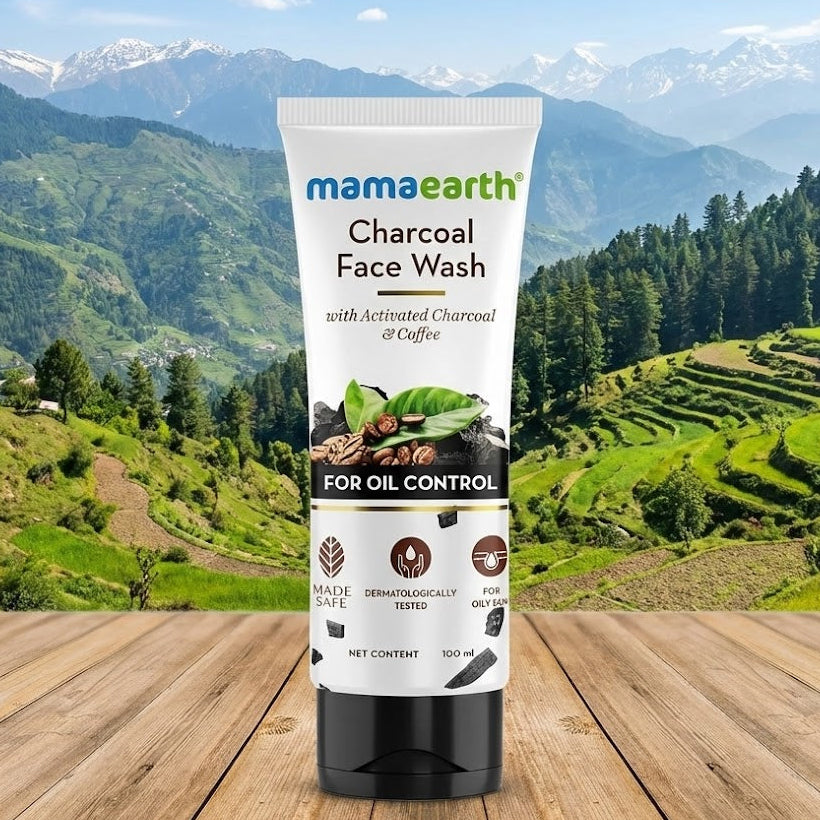 Mamaearth Charcoal Face Wash tube with a mountainous landscape in the background