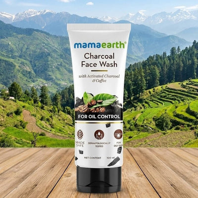Mamaearth Charcoal Face Wash tube with a mountainous landscape in the background