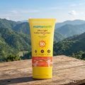 Yellow tube of mamaearth sunscreen with a mountainous landscape in the background