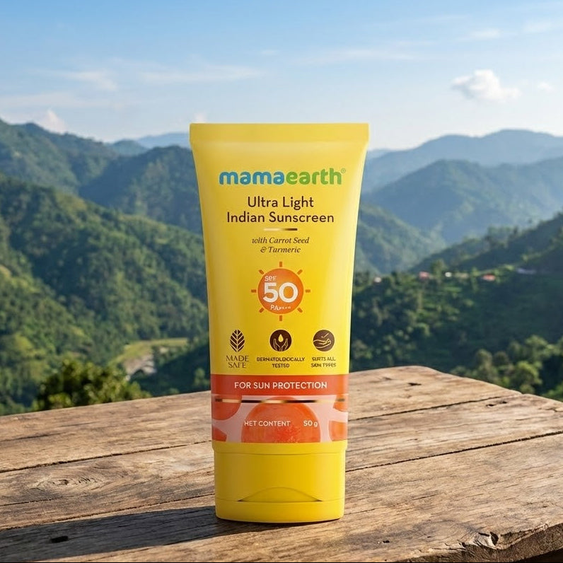 Yellow tube of mamaearth sunscreen with a mountainous landscape in the background