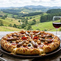 Pizza on a table with a scenic view of hills and trees in the background