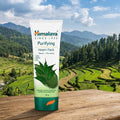 Himalaya Purifying Neem Pack tube with a scenic background of mountains and greenery.