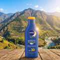 Nivea sun care bottle with a scenic mountain backdrop
