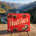 Cadbury Nutties box on a wooden surface with a mountainous landscape in the background