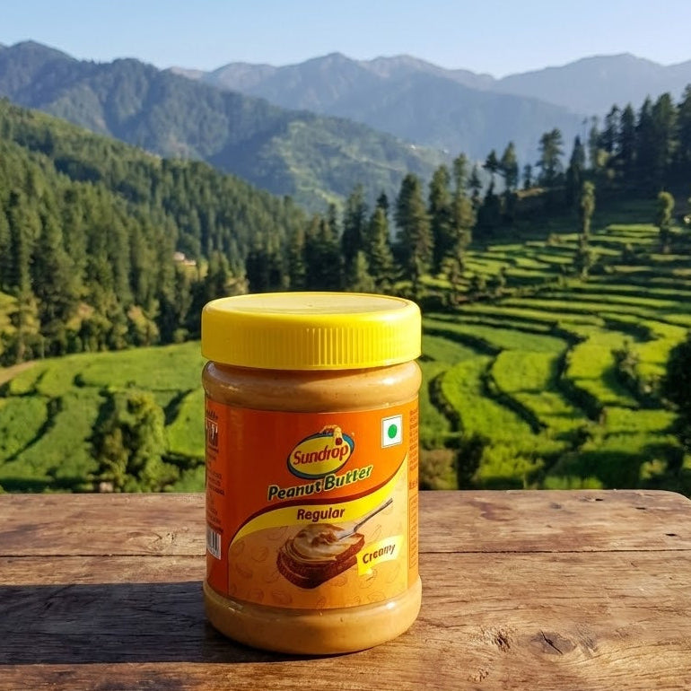 Jar of SunButter peanut butter on a wooden surface with a scenic mountain background