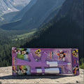Toy gun with Minnie Mouse design on a rock in front of a mountainous landscape