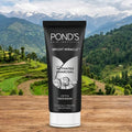 Pond's Skin Institute Bright Miracle Activated Charcoal Facewash tube with a mountainous landscape in the background