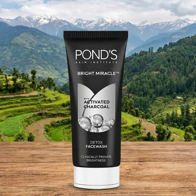 Pond's Skin Institute Bright Miracle Activated Charcoal Facewash tube with a mountainous landscape in the background