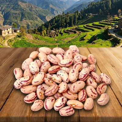 Pile of pink beans on a wooden surface with a scenic mountain landscape in the background