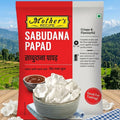Mother's Recipe Sabudana Papad packaging with a bowl of papad on a wooden table with a scenic background.