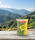 Rajdhani Moong Sabut package on a wooden surface with a mountainous landscape in the background