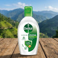 Dettol bottle on a wooden surface with a mountainous landscape in the background