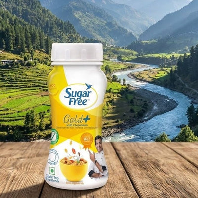 Sugar Free Gold+ container on a wooden surface with a scenic mountain landscape in the background