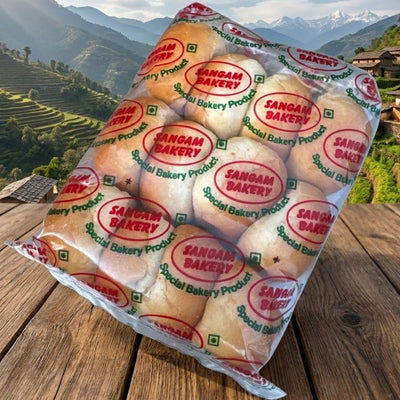 Packaged bread with 'Sangam Bakery' branding against a scenic mountain backdrop.