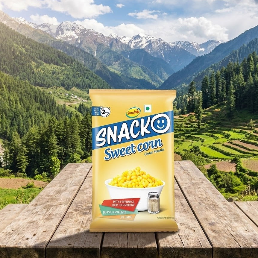 Snacko Sweet Corn packet on a wooden table with a mountainous landscape in the background