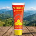 Vicco Turmeric cream tube with a mountainous landscape in the background