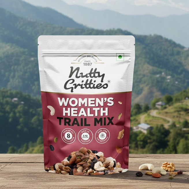 Nutty Gritties Women's Health Trail Mix package on a wooden surface with a mountainous landscape in the background